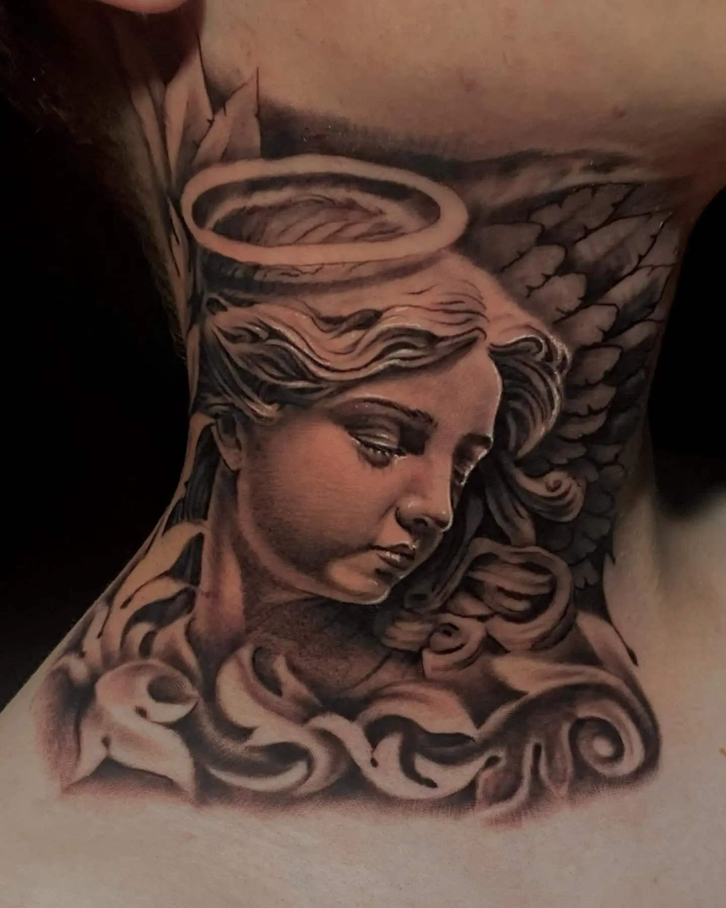 Anjo com auréola em realismo preto e cinza no pescoço