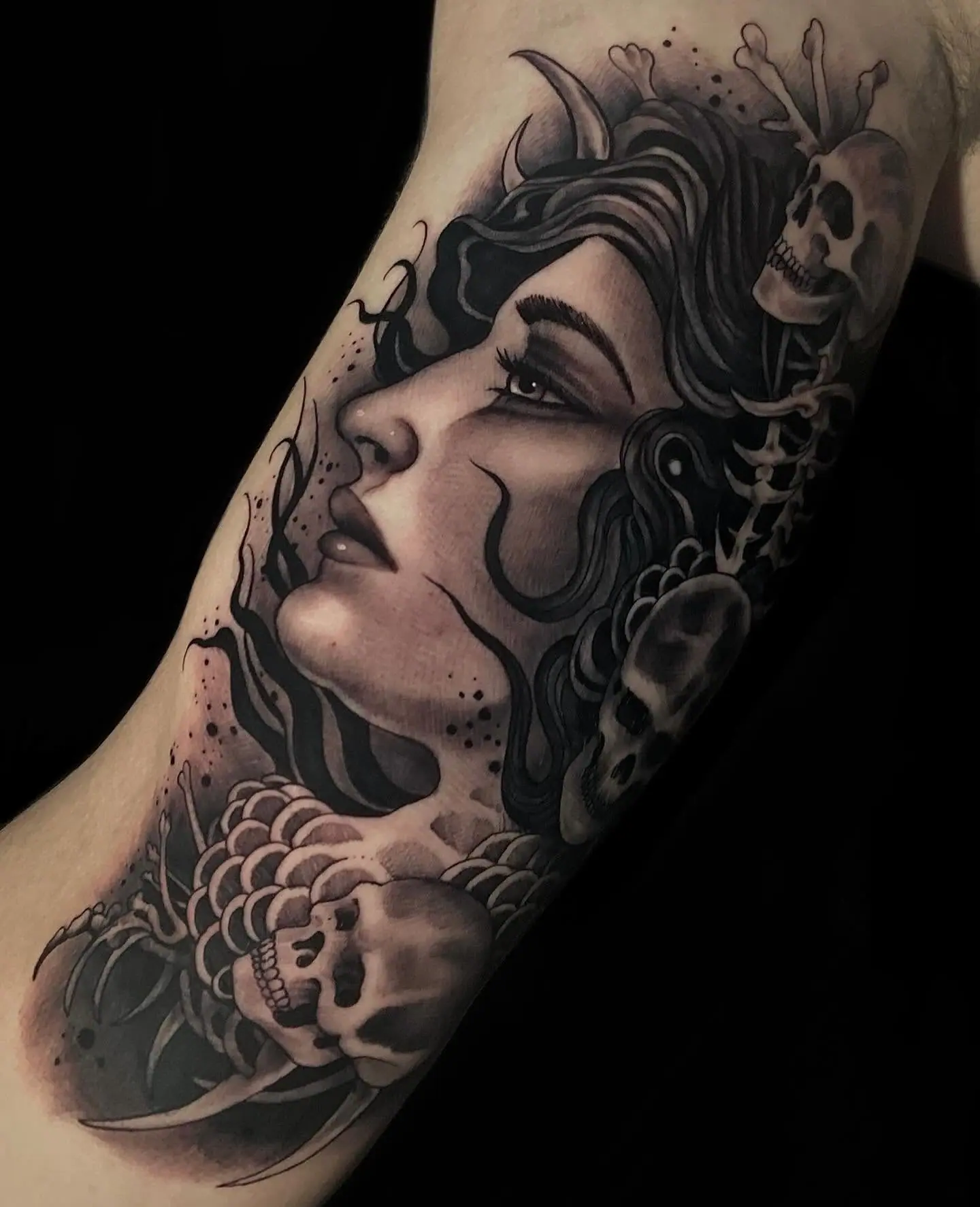 Rosto feminino com caveira em realismo dark no braço