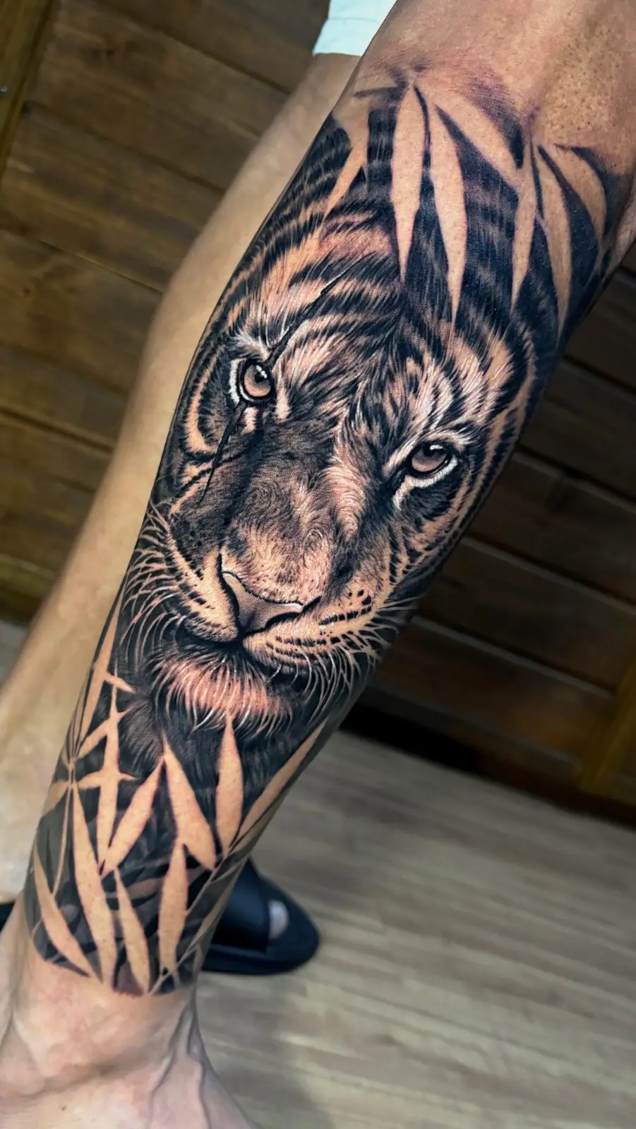Tigre entre folhagens em realismo no antebraço