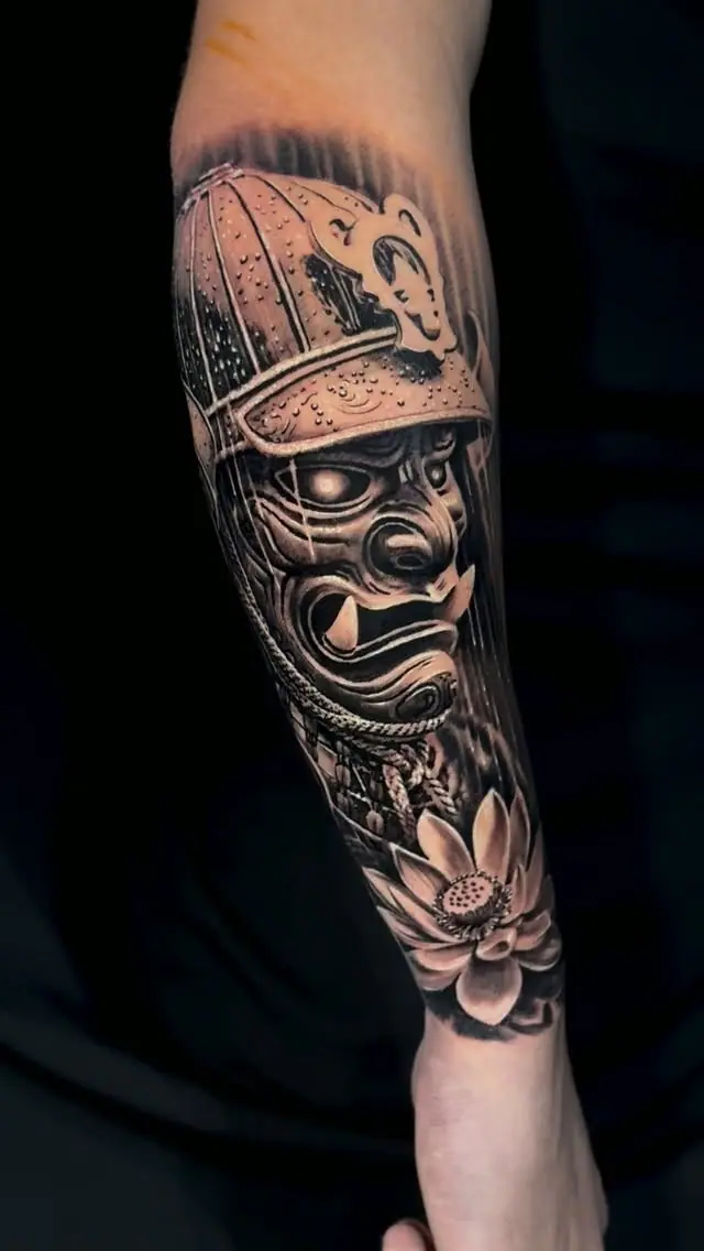 Máscara de samurai com flor de lótus no antebraço